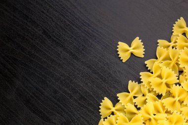 Farfalle makarna boşaltmak koyu siyah zemin üzerine yığını A sınır