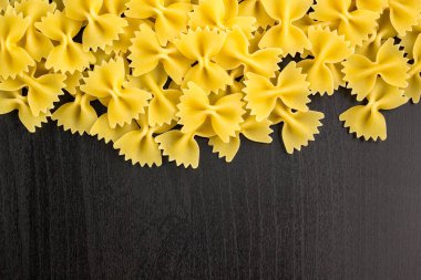 Farfalle makarna boşaltmak koyu siyah zemin üzerine yığını A sınır