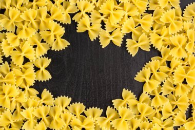 Copyspace ile koyu siyah arka plan üzerinde farfalle makarna bir yığın Çerçeve