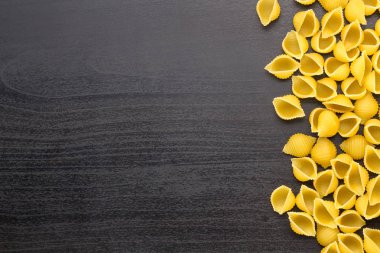 Copyspace ile siyah arka plan üzerinde conchiglie yapıştırma kabukları yığınının kenarlığı