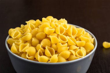 kopya alanı ile kase İtalyan ham conchiglie yapıştırın kabukları ile siyah arka plan