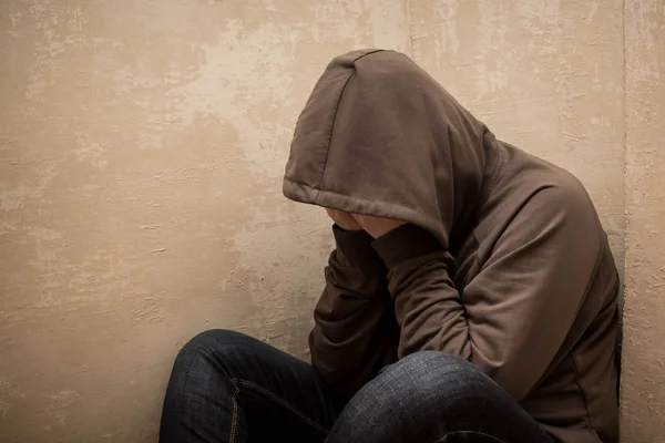 Adam üzgün, köşede katta oturan uyuşturucu bağımlısı adam portresi