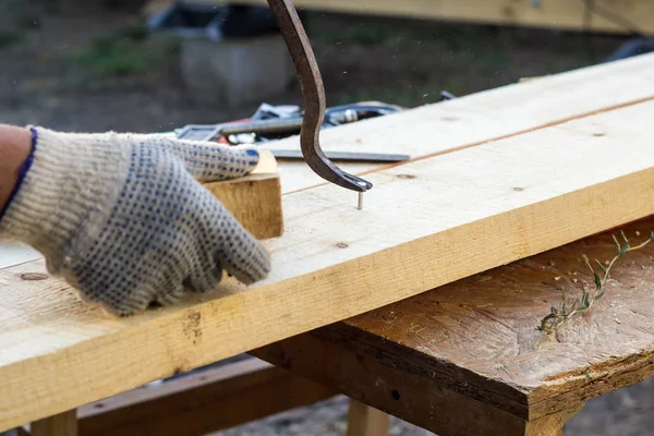 木匠用爪锤从木板上拔钉子 — 图库照片