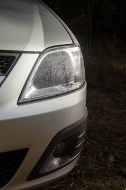 Gümüş boyalı parlak araba. Kaputun üzerine su damlaları.