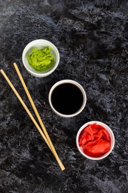 Taş arka planda çubuk ile suşi soya sosu zencefil wasabi için ayarlayın