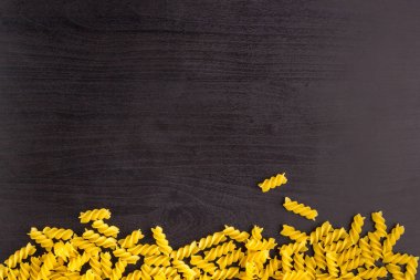 Copyspace ile siyah arka plan üzerinde makarna spiral fusilli bir yığın Sınır