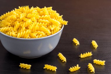 kopya alanı ile kase İtalyan ham makarna spiral fusilli ile siyah arka plan