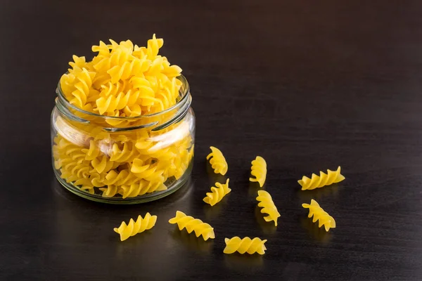Delicious traditional pasta spiral fusilli macaroni in the glass jar — Stock Photo, Image