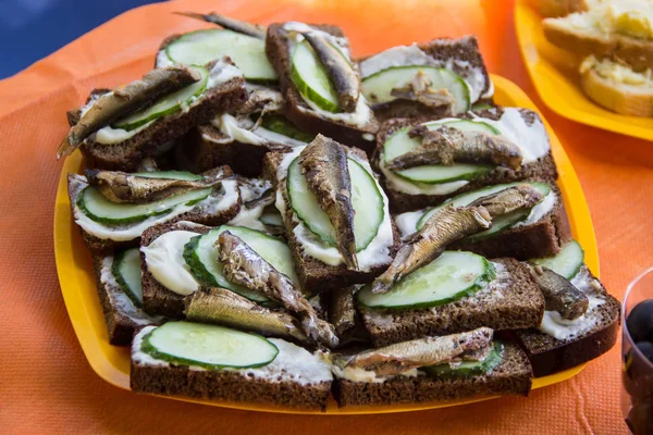 Sandwiches with smoked sprats and fresh cucumbers on an orange background — Stock Image Sandwiches with smoked sprats and fresh cucumbers on an orange background Royalty Free Stock Photos