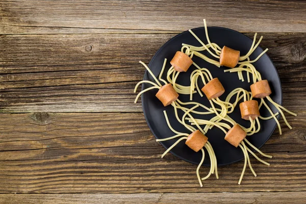 Spaghetti med korv i form av spindlar. Glad barnmat till Halloweenfesten. Ovanifrån med copyspace — Stockfoto