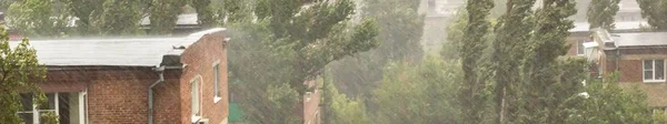 Bandeira de chuva pesada, árvores, arame e casa residencial na aldeia — Fotografia de Stock