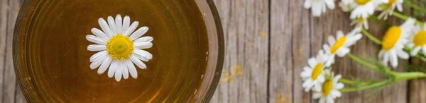 Banner der Tasse Tee mit Kamillenblüten auf rustikalem Holzgrund — Stockfoto