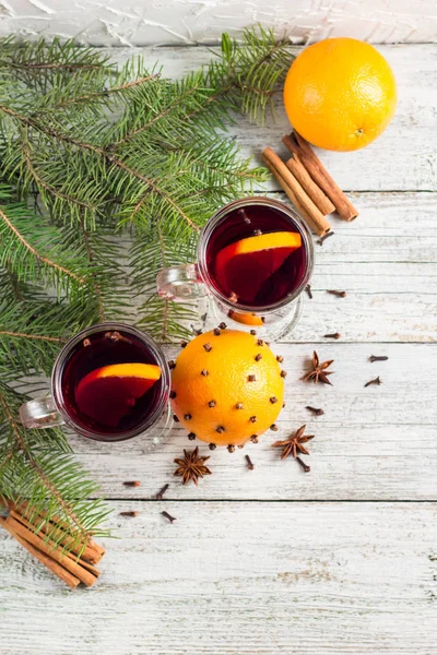 Vino caliente con especias de Navidad con canela naranja y anís sobre fondo de madera blanca — Foto de Stock