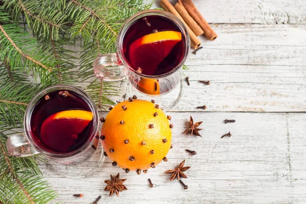 Vino caliente con especias de Navidad con canela naranja y anís sobre fondo de madera blanca — Foto de Stock