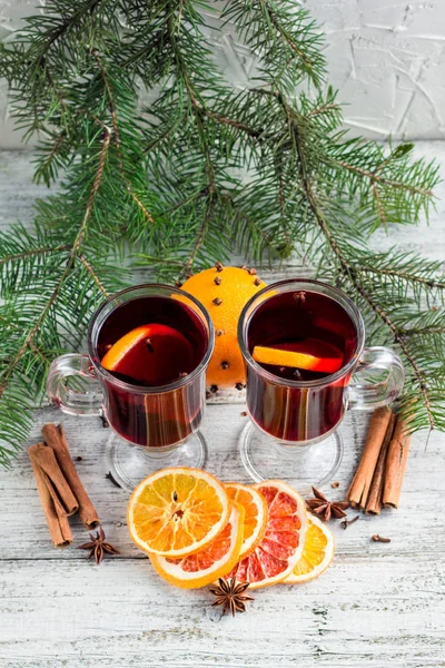 Vino caliente con especias de Navidad con canela naranja y anís sobre fondo de madera blanca — Foto de Stock