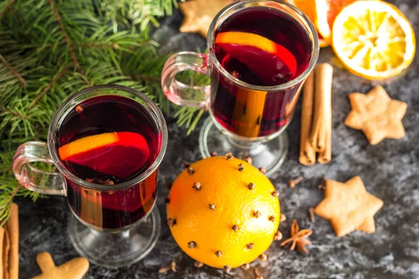 Vino caliente de Navidad con galletas de jengibre naranja canela clavo de olor anís y abeto en la mesa oscura — Foto de Stock