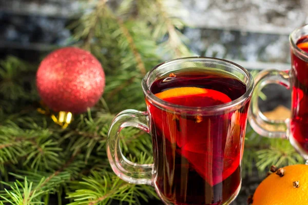 Vino caliente de Navidad con galletas de jengibre naranja canela clavo de olor anís y abeto en la mesa oscura — Foto de Stock