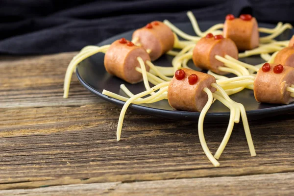 Спагетти с сосисками в виде пауков. Счастливая детская еда на Хэллоуин. copyspace — стоковое фото
