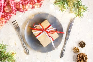 Beyaz masa üzerinde plaka üzerinde hediye ile Noel tablo ayarı. Xmas kavramı üstten görünüm
