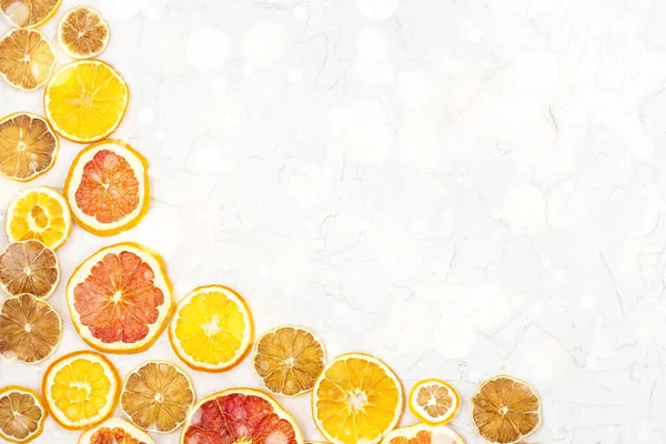 Border of Dried slices of various citrus fruits on white background. Orange lemon grapefruit with copyspace