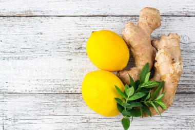 Taze zencefilli limon ve beyaz ahşap zemin üzerinde nane.