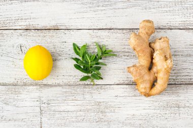 Taze zencefilli limon ve beyaz ahşap zemin üzerinde nane.