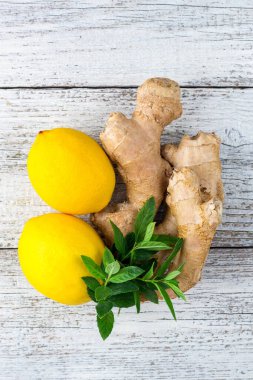 Taze zencefilli limon ve beyaz ahşap zemin üzerinde nane.