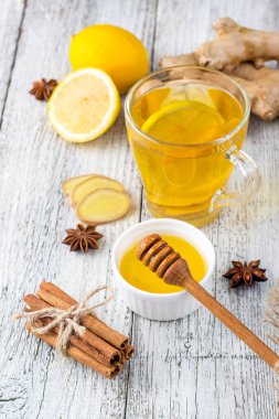 Beyaz ahşap arka planda zencefil, limon, bal ve baharatlı sonbahar çayı.