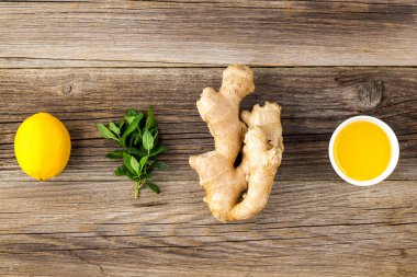 Zencefil kökü nane ve bal malzemesi, ahşap arka planda doğal sıcak içecek için.