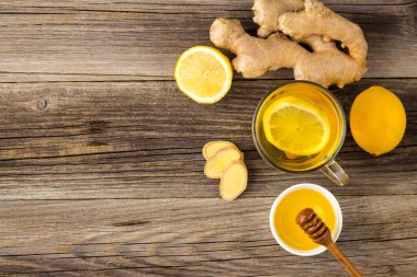 Ahşap zemin üzerinde limonlu ve ballı zencefil çayı. Sıcak, sağlıklı kış içeceği