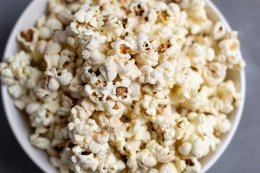 Gri masada beyaz kasede patlamış mısır. Kopyalama alanı olan üst görünüm