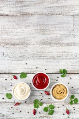 Beyaz ahşap arka planda baharatlı çeşitli soslar. Mayonez ketçap hardalı. Kopyalama alanı olan üst görünüm