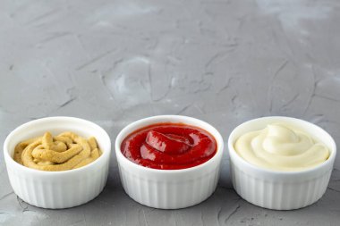 Gri taşlı arka planda üç çeşit klasik sos. Kopya alanı ile mayonez ketçap hardalı