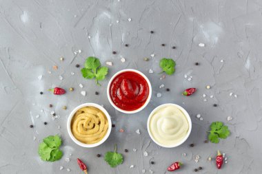 Gri taş arka planda baharatlı çeşitli soslar. Mayonez ketçap hardalı. Kopyalama alanı olan üst görünüm