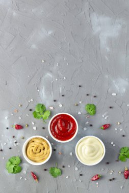 Gri taş arka planda baharatlı çeşitli soslar. Mayonez ketçap hardalı. Kopyalama alanı olan üst görünüm