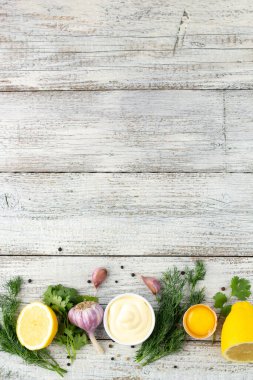 Sarımsak sosunun içeriği. Beyaz ahşap arka planda mayonez hazırlamak için ürünler. Kopyalama alanı olan üst görünüm