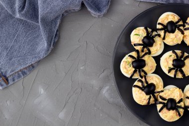 Cadılar Bayramı partisi için örümcekli yumurta. Peçeteli çocuklar için eğlenceli yemek. Boşluğu kopyala