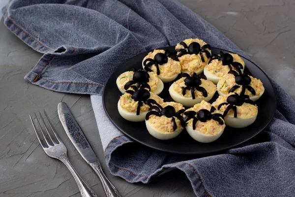 Deviled Eggs With A Spider For Halloween Party. Fun food for kids with napkin fork and knife
