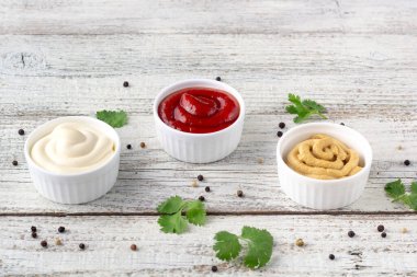 Beyaz ahşap arka planda baharatlı çeşitli soslar. Mayonez ketçap hardalı. en üstteki görünüm