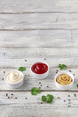 Beyaz ahşap arka planda baharatlı çeşitli soslar. Mayonez ketçap hardalı. Kopyalama alanı olan üst görünüm