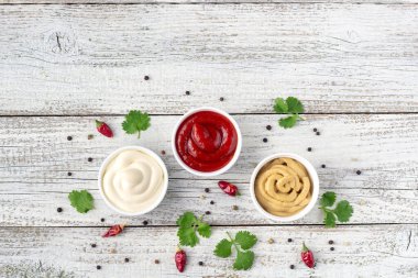 Beyaz ahşap arka planda baharatlı çeşitli soslar. Mayonez ketçap hardalı. Kopyalama alanı olan üst görünüm