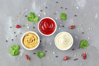 Gri taş arka planda baharatlı çeşitli soslar. Mayonez ketçap hardalı. en üstteki görünüm