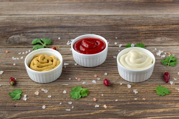 Doğal ahşap arka planda baharatlı çeşitli soslar. Mayonez ketçap hardalı. Kopyalama alanı olan üst görünüm