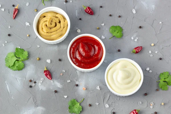 Gri taş arka planda baharatlı çeşitli soslar. Mayonez ketçap hardalı. en üstteki görünüm