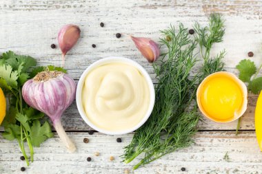 Sarımsak sosu malzemeleri. Beyaz ahşap arka planda mayonez hazırlamak için ürünler. Kopyalama alanı olan üst görünüm