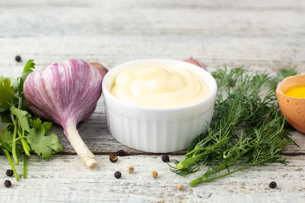 Sarımsak sosunun içeriği. Beyaz ahşap arka planda mayonez hazırlamak için ürünler. Kopyalama alanı olan üst görünüm