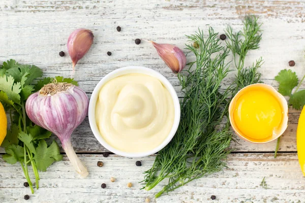 Sarımsak sosu malzemeleri. Beyaz ahşap arka planda mayonez hazırlamak için ürünler. Kopyalama alanı olan üst görünüm