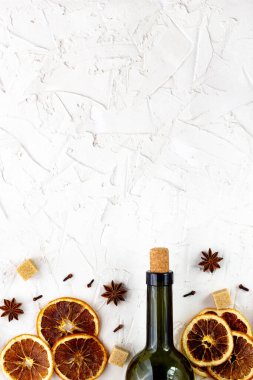 Beyaz arka planda bir şişe şarap ve baharat. Sıcak bir şarap için malzemeler. Tarçın, anason yıldızı, portakal, esmer şeker, karanfil. Noel sıcak içeceği
