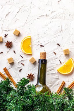 Sıcak şarap için düz bir malzeme döşemesi. Noel sıcak içecek tarifi. Bir şişe şarap, portakal, şeker, tarçın çubukları, anason ve köknar dalları. Kopyalama alanı olan üst görünüm