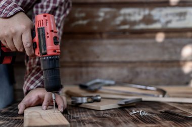 Marangoz dükkanında çalışan bir marangoz. Mobilya için ahşap işçiliği ve ev dekorasyonu konsepti. Dekorasyon için DIY tahtası.